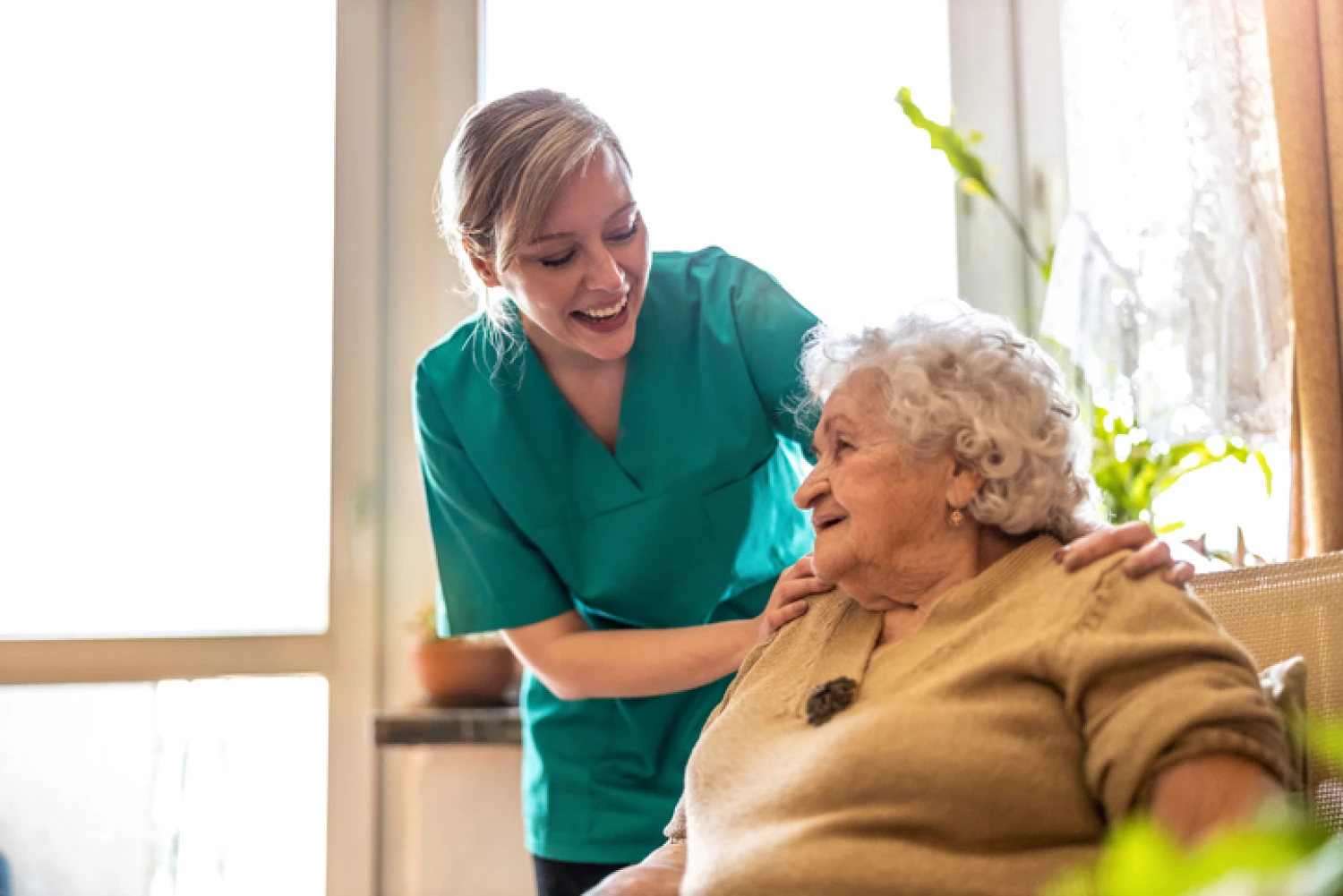 Friendly caregiver assisting an elderly woman at home, demonstrating comprehensive assistance through a Home Care Package Level 4.