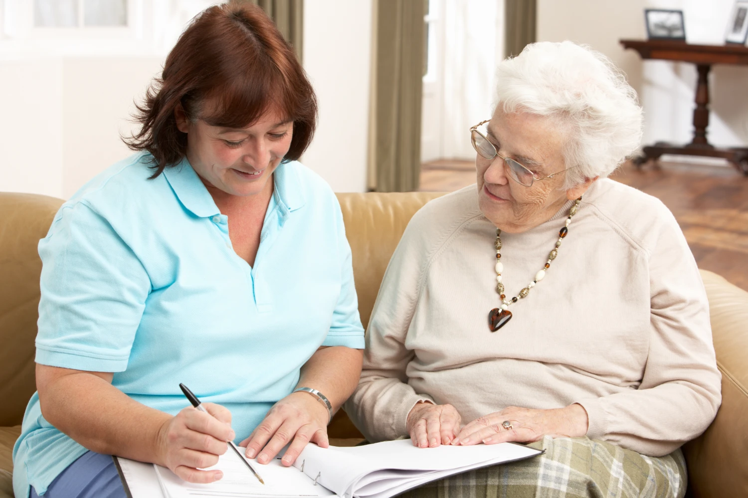 Woman reviewing NDIS plan with support coordinator, discussing day program options