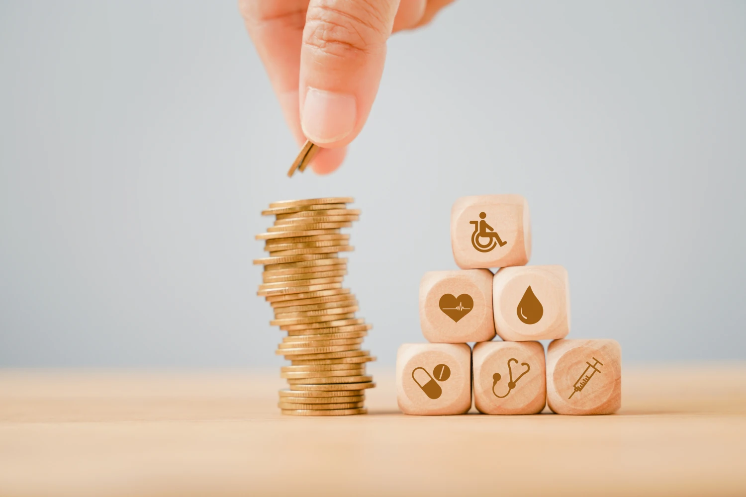 Stacked coins representing NDIS funding next to cubes with images relating to NDIS supports - Focus Care