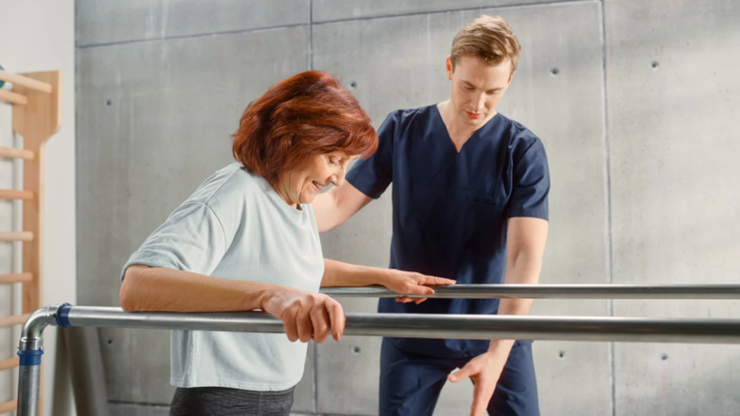 Occupational therapist assisting a middle-aged woman with walking exercises in a rehabilitation setting to enhance mobility.