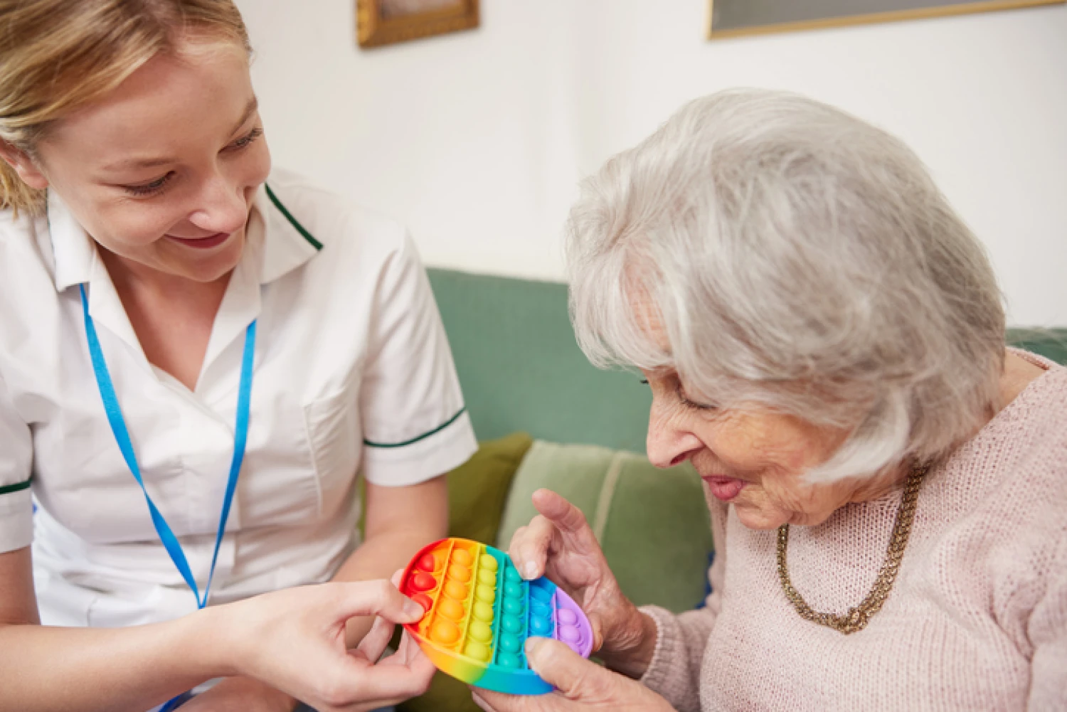 Occupational therapist using sensory stimulation tools to improve dementia patient’s memory in a home setting.