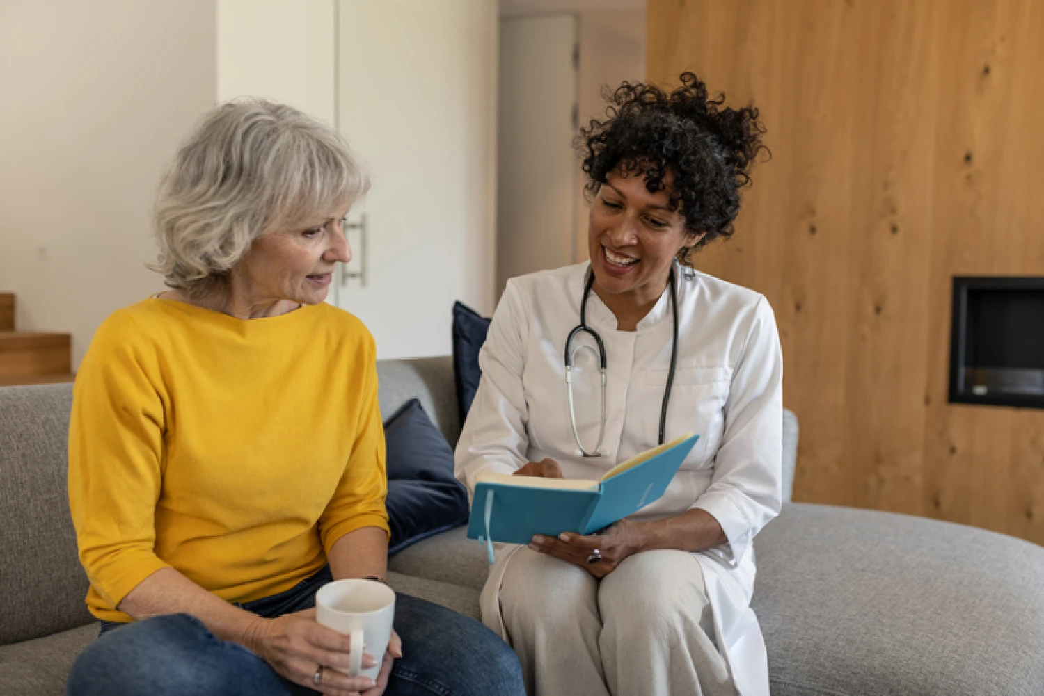 Private care provider discussing a care plan with an elderly woman, illustrating personalised care management.